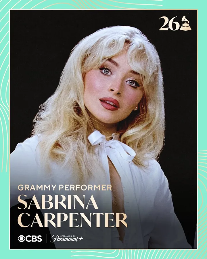Close-up portrait of a young woman with blonde hair styled in soft waves, wearing a white blouse with a bow, looking directly at the camera.