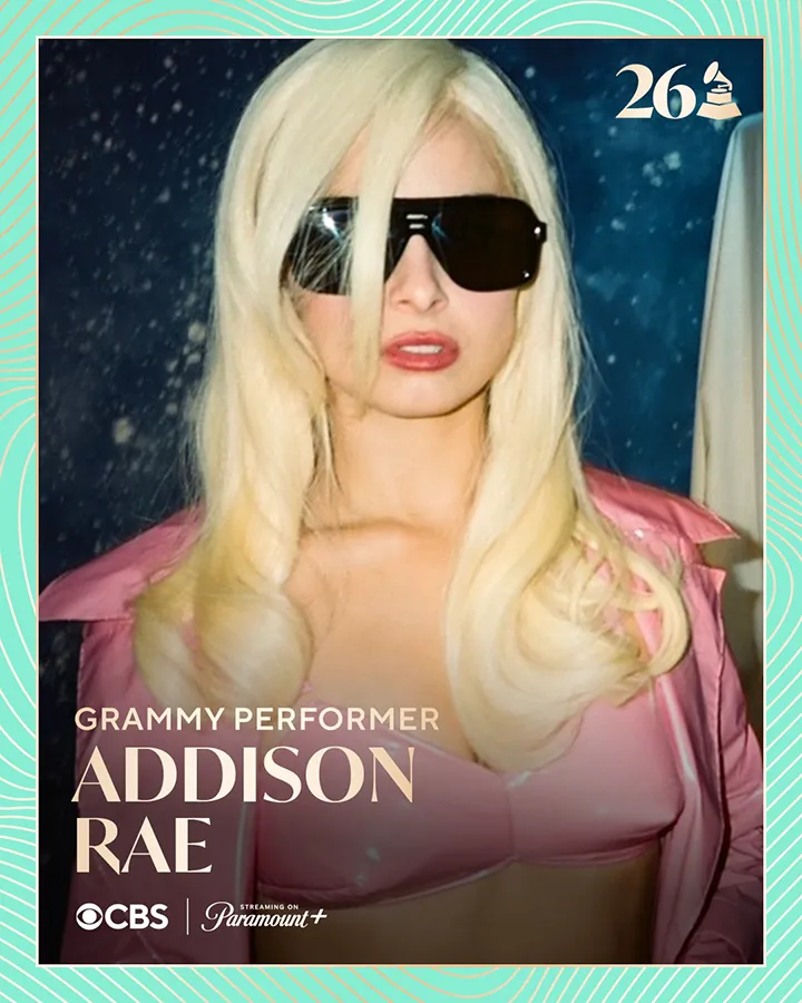 A young woman with long blonde hair wearing sunglasses and a pink outfit, posing against a dark, starry background. The text labels her as 'Grammy Performer Addison Rae' with CBS and Paramount+ logos.