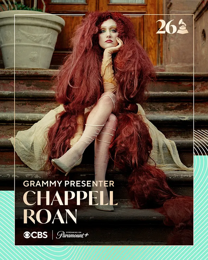 A seated woman with long, voluminous red hair, wearing a beige dress and stockings, poses on a staircase. The image promotes her as a Grammy presenter, with CBS and Paramount+ branding.