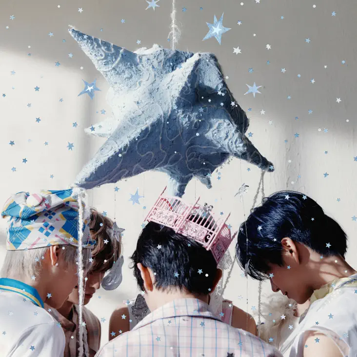 Album Cover for NCT WISH The 1st Album – Ode to Love (2026). Four people gathered around a large blue star-shaped decoration, adorned with lace, with light blue and white stars scattered around the scene.