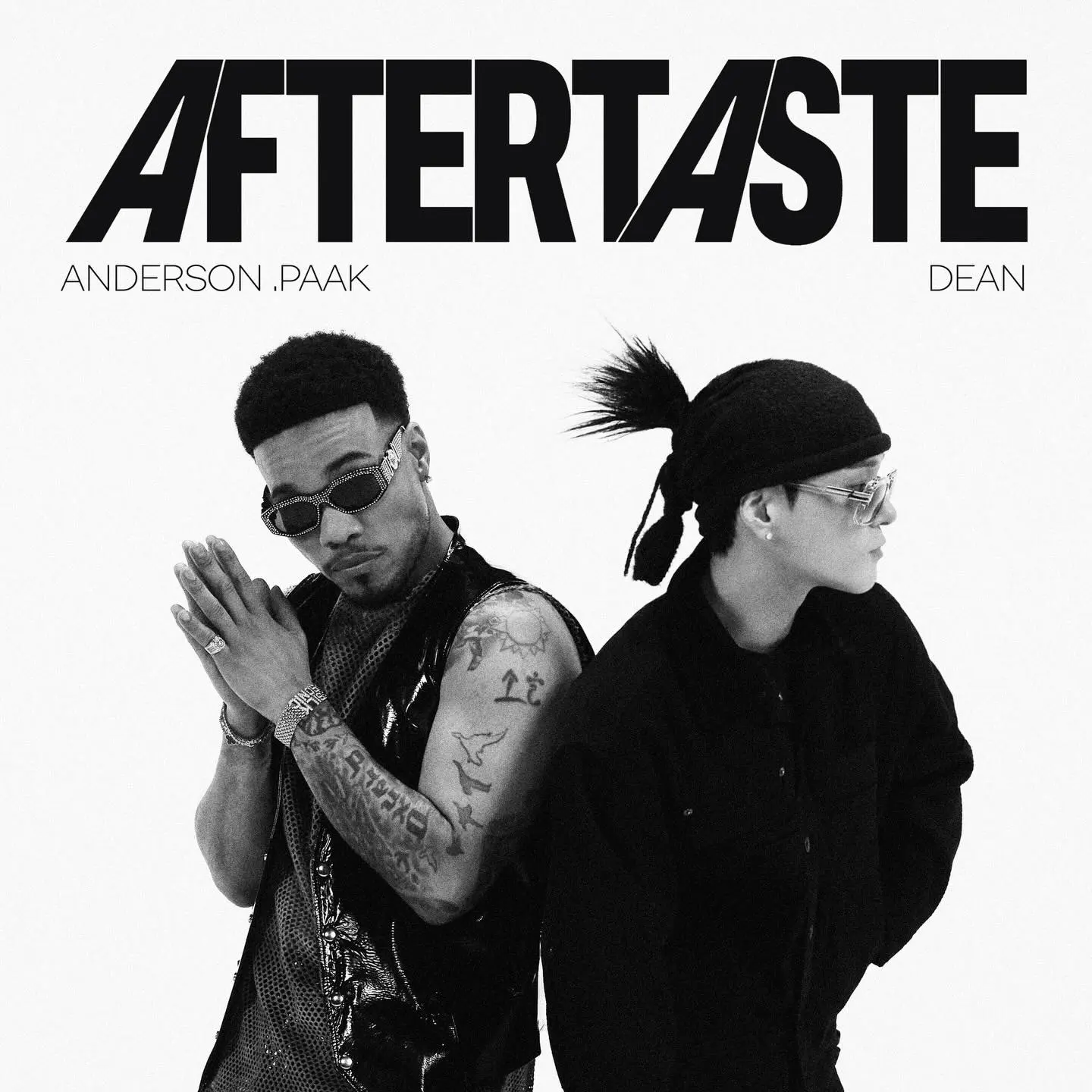 Black and white image featuring Anderson .Paak and Dean, both wearing sunglasses and stylish outfits, with the title 'AFTERTASTE' prominently displayed above them.
