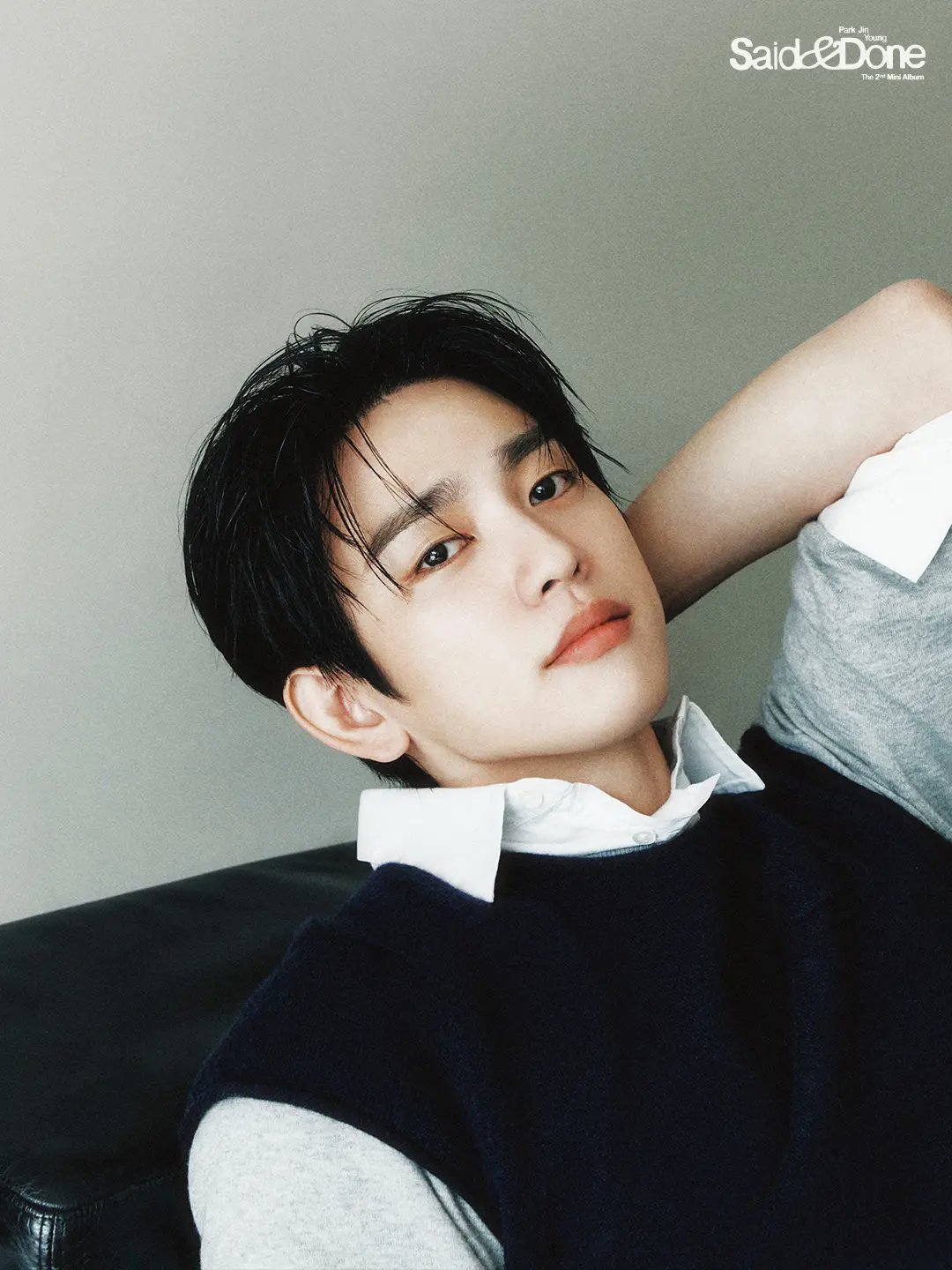 PARK JIN YOUNG 2nd Mini Album – Said & Done (2026) Teaser. A young man with dark hair and a stylish outfit, reclining against a couch, looking directly at the camera with a thoughtful expression.